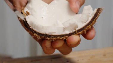 Adam kabuğundan bıçakla beyaz hindistan cevizi hamuru çıkarıyor..