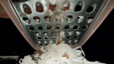 Grating Coconut Pulp on a Grater to Make Sweet Shavings, Makro View from a Low Angle, Under the Metal Mash.