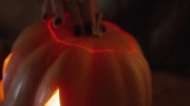 Parlak mum ışığı Fenerin içinde, Kadın oyulmuş Lid 'i kaldırır ve içine bakar..