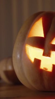 Dikey video. Cadılar Bayramı Masadaki Balkabakları, Mum Işığından Karanlıkta Ev Ayarları. Kaydırıcı.