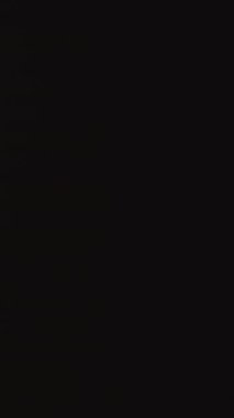 Dikey video. Buzdolabının Kapısı Karanlık Oda 'da Açılıyor ve Parlayan Cadılar Bayramı Balkabağının İçinde Ürkütücü Gülümseme ve Gözleriyle. Cadılar Bayramı Korku Konsepti.