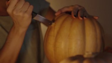 Cadılar Bayramı Sembolünü Bir Kadın Oluyor, Balkabağındaki Kalem Taslaklarını İzliyor. Evde Sıcak Bir Akşam.