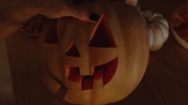 Mum Işığının Karanlığında, Bir Kadın Bıçakla Fener Oyuyor, Diş ve Ağız Yapıyor. Cadılar Bayramı için hazırlanılıyor.