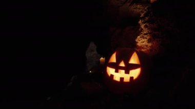 Balkabağı balkabağı, duvarlar boyunca dizilmiş mumlarla mağarayı süslüyor. Cadılar Bayramı gecesinde ürkütücü atmosfer.