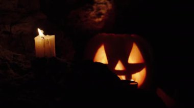 Karanlık Mağara ve Cadılar Bayramı Balkabağı Gülüşü ve Korkunç Gözler, Rüzgârın Söndürdüğü Mum ve Parlak Işık Jack-O-Lantern 'in İçinde.