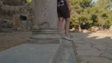 Tarihsel Harabeleri Keşfeden, Geçmişin Yankılarına Batmış, Uzun Taş Sütunların Ardında Dolaşan Bir Kadın.