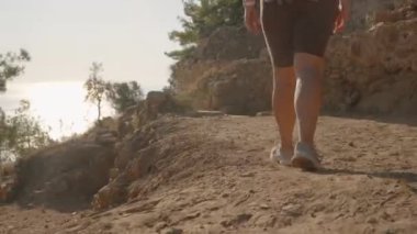 Batan Güneş 'in silueti altında, Antik Yol boyunca yürüyen bir kadın, Harabelerin Huzurlu Güzelliği' ne gömülmüş..