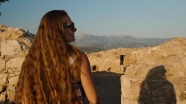 Majestic Mountain Views 'da, harabelerin arasında duran bir kadın, Öğleden Sonra' nın yumuşak ışığında yıkandı..