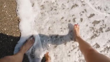 Yumuşak Dalgalar Ayaklarını Yıkarken Bir Aile Sahil boyunca Yürüyor. Yavaş Çekim Efekti Bir Plaj Gezisinin Neşe ve Huzurunu Yakalıyor, Bağlantı ve Doğayı Vurguluyor.