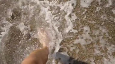 Dalgalarla Islak Kumda Yürüyen Bir Adamın Ayakları. Yavaş Çekim Efekti Doğayla Bağlantıyı ve Sahil Yürüyüşünün Huzurlu Ritmini Vurguluyor.