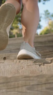 Dikey video. Yavaş Sinema Dizisi Bir Kadının Yükselen Ahşap Adımlarını İzler, Huzur Ormanı 'nda Ayak Sesleri Yankılanır.