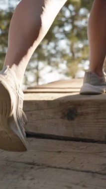 Dikey video. Her Adımına Odaklanan Kadının Ayakları Yavaş Çekimde Nazikçe Yüksel, Doğanın Huzuru Çevrelenmiş..