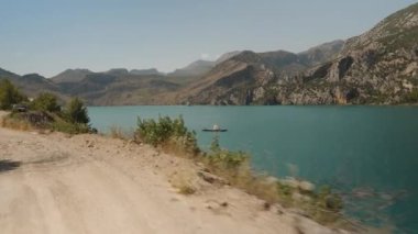 Engebeli Dağlarla çevrili Sakin Göl, Yavaşça Yüzen Tekneler, Yavaş Çekimde Barışçıl Atmosfer Yanı Başında Sahne Sürücüsü.