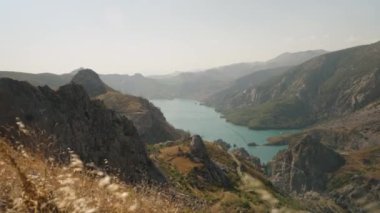 Turkuaz Gölü 'nün Genişletici Vista' sı Engebeli Dağlar Arasında Sarsılıyor, Güneş Işığı Dramatik Araziyi Vurguluyor, Doğayı Yakalamak İçin Mükemmel.