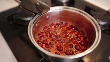 Sobadaki bir tencerede kaynayan kirazlar. Zenginler, Koyu Kırmızı Renkler Lezzetli Tatlı ve Tatlılar Yapımında Komplo.