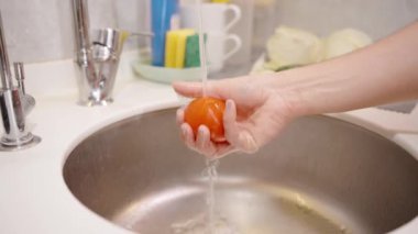 Domatesin Üzerinde akan su, Pişirmek için temiz olmasını sağlamak..