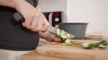 Genç Kadın Malzemeleri Hazırlıyor, Besleyici Yemek İçin Salatalıkları Dilimliyor.