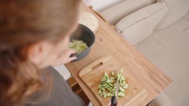 Öğle Yemeğini Hazırlayan Genç Kadın Salataya Salatalık Dilimliyor.