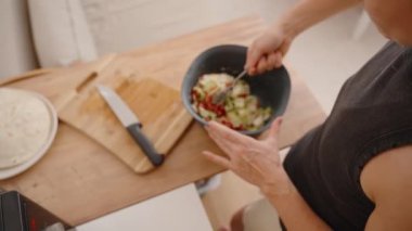 Salatanın iyice karıştırılması, tüm malzemelerin eşit şekilde kaplandığından emin olmak..