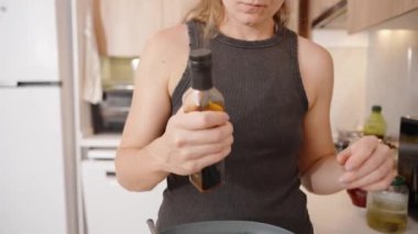 Genç kadın salataya nar sosu ekliyor, tatlı ve keskin tadını arttırıyor..