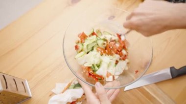 Salatanın nazikçe fırlatılması, tüm malzemelerin eşit karışımlı ve aromalı olmasını sağlamak..