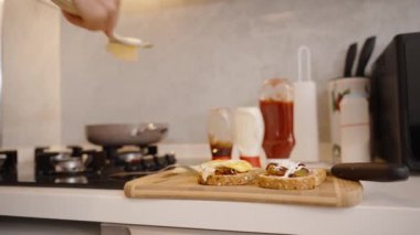 Pişmiş yumurtanın üzerine bir dilim peynir koymak, lezzetli bir sandviç yapmak..