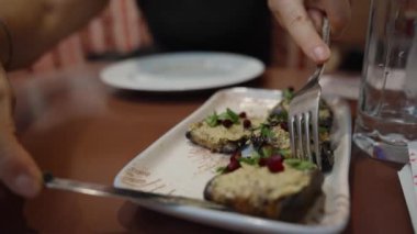 Taze otlar ve nar tohumlarıyla süslenmiş bir çatal dolusu kızarmış patlıcanın tadını çıkarıyorum..