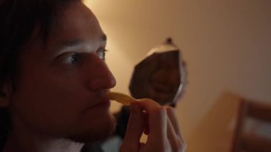 Düşüncelere dalmış, elinde bir çip tutarken düşünüyor. Odaklanmış bakışları ve yumuşak parıltısı ambiyansı artırıyor..