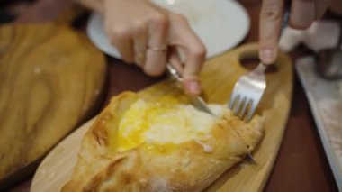 Isırığın tadını çıkaran genç bir kadın, yemeğinin zengin lezzetlerinden zevk alır. Her lokma peynir ve ekmeğin mükemmel karışımıyla dolu..