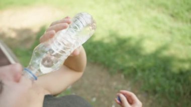 Yakından bakınca, genç bir kadın su içiyor. Yakın çekim doğadaki canlandırıcı anı yakalar..
