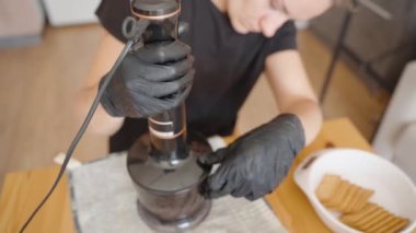 Odaklanmış ve Kararlı Bir Kadın Kurabiyeleri Ezmek İçin Yemek İşlemcisini İşletiyor. Sahne, Tarifte Tutarlılığın Önemi 'ni vurgular.