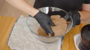 Ezilmiş Kurabiye Karışımına Tereyağı Ekleniyor, İçindekileri Birleştirmeye Hazırlanıyor. Sahne, Ev Yapımı Tatlının Özünü Yakalıyor.