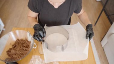Parşömen kağıdıyla Metal Kek Yüzüğü Hazırlama, Üs için Hazırlama. Sahne, Tatlılar Toplantısında Hassasiyet ve Organizasyonu Yansıtır.