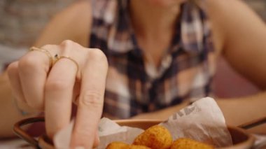 Kadın Lezzetli Kızarmış Aperatiften Bir Isırık, Rahat Bir Kafede Lezzetin Tadını Çıkartıyor.