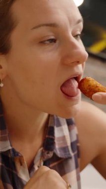 Dikey video. Peynirli çerezin tadını deneyimleyen kadın, Yapışkan Peynir Tadına Eğlence Elementi ekliyor.