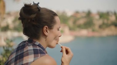 Lolipoplu Kadın, Güzel Bir Gün 'de Deniz Tarafından Manzaranın Tadını Çıkartıyor.