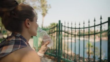 Kadın, Sahilde Su İçmekten, Güneşli bir günde dinlenmekten hoşlanıyor..