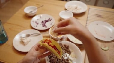 Bir Kişi Peynir ve Sebzelerle Bir Taco Üstü, Renkli ve Lezzetli Bir Yemek Hazırlıyor.