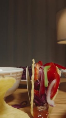 Dikey video. El, Taco 'ya Avokado Dilimleri Ekler, Taze İçindekilerle Lezzeti Arttırır.