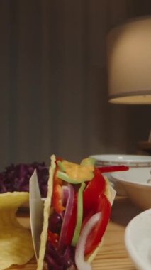 Dikey video. El Tuzlanmış Peyniri Taco 'ya ekler, Renkli ve Lezzetli İçindekileri Doldurur. Dolly kaydırıcı, kapat..