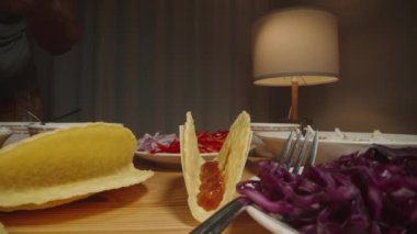Dilimlenmiş tavuğu tako kabuğuna ekler ve lezzetli bir taco hazırlamaya başlar. Dolly kaydırıcı, kapat..