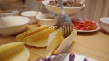 Kadın tako kabuğuna kıyma ekliyor, nefis bir ev yapımı taco hazırlıyor..
