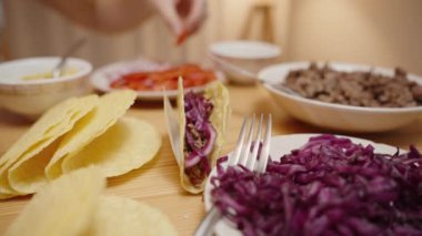 Kadın, Taco 'ya Kirazlı Domates Dilimleri Ekliyor, Lezzet ve Rengi Artırıyor.