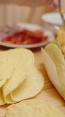 Dikey video. Kadın Taco 'ya peynir sosu ekliyor, Tuzlu ve peynirli dolgu yapıyor..