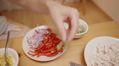 Kadın Taco 'ya Avokado Dilimleri Ekliyor, Taze ve Renkli Doldurmayı Tamamlıyor.