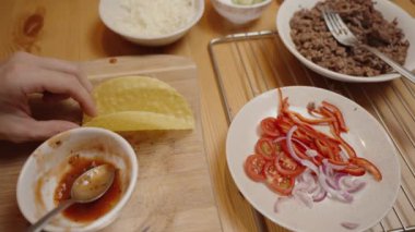 Salsa soslu taco hazırlayan ellerin yakın çekimi, taze sebzeler, ve Ground Meat, Lezzetli Ev Yapımı Yemekler.