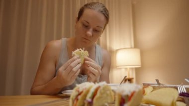 Bir kadın taze malzemelerle dolu nefis bir taco 'dan bir ısırık almak için eğildi..