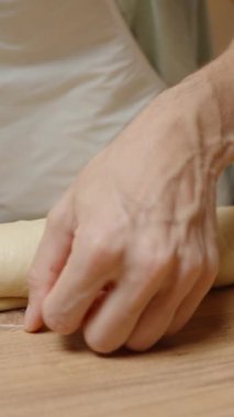 Dikey video. Yuvarlanan Hamuru Dişlerinin Dişleriyle Dilimlemek, Temiz Kesikleri Sağlamak.