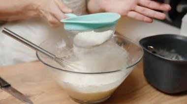 Karışık bir kasenin üzerine nazikçe un serpmek, Pişirmek için Lump-free karışımını garantilemek.