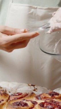 Dikey video. Sıcak ruloların üzerine krema serpiştirmek, Bitirici Dokunuş eklemek.